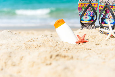 Multi colored pencils on sand at beach