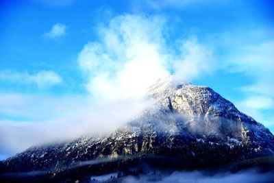 Snow covered mountain against blue sky