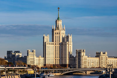 Modern buildings in city against cloudy sky