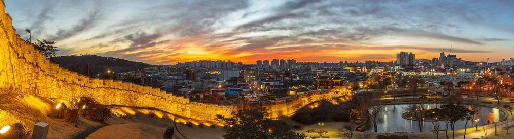 Great wall of china and buildings in city lit up at dusk