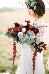 Midsection of bride holding bouquet