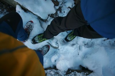 Low section of man standing on snow