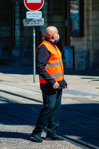 Full length of man standing on road in city