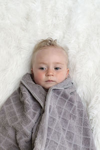 High angle view of cute baby lying down on bed