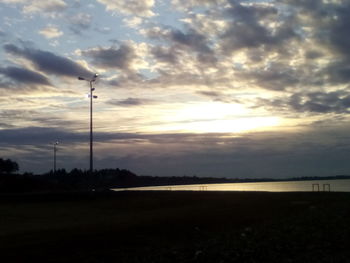 Scenic view of silhouette field against sky at sunset