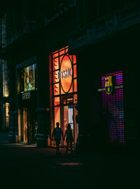 People in illuminated building at night