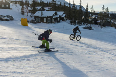 Cyclist and skier compete in ski slopes