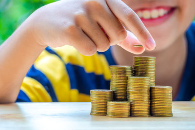 Boy stacking coins on table