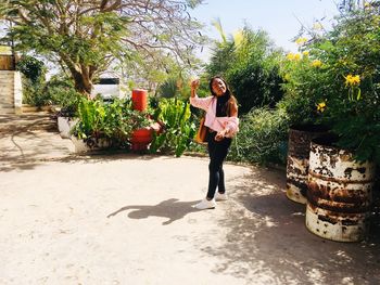 Young woman with eyes closed standing against plants