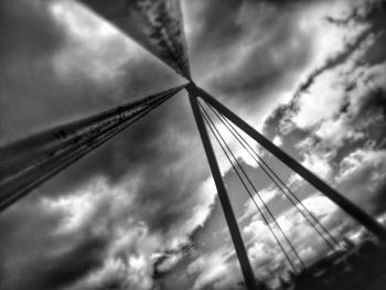 Low angle view of metallic structure against cloudy sky