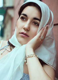 Young woman looking away while sitting outdoors