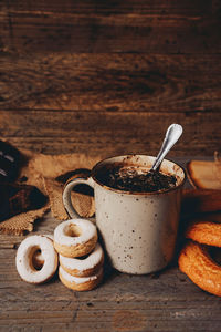 Hot chocolate by doughnuts on table