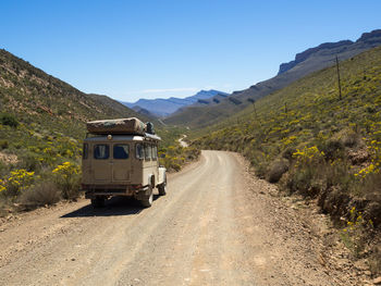 Road amidst mountains against clear sky