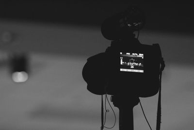 Close-up of silhouette camera against sky