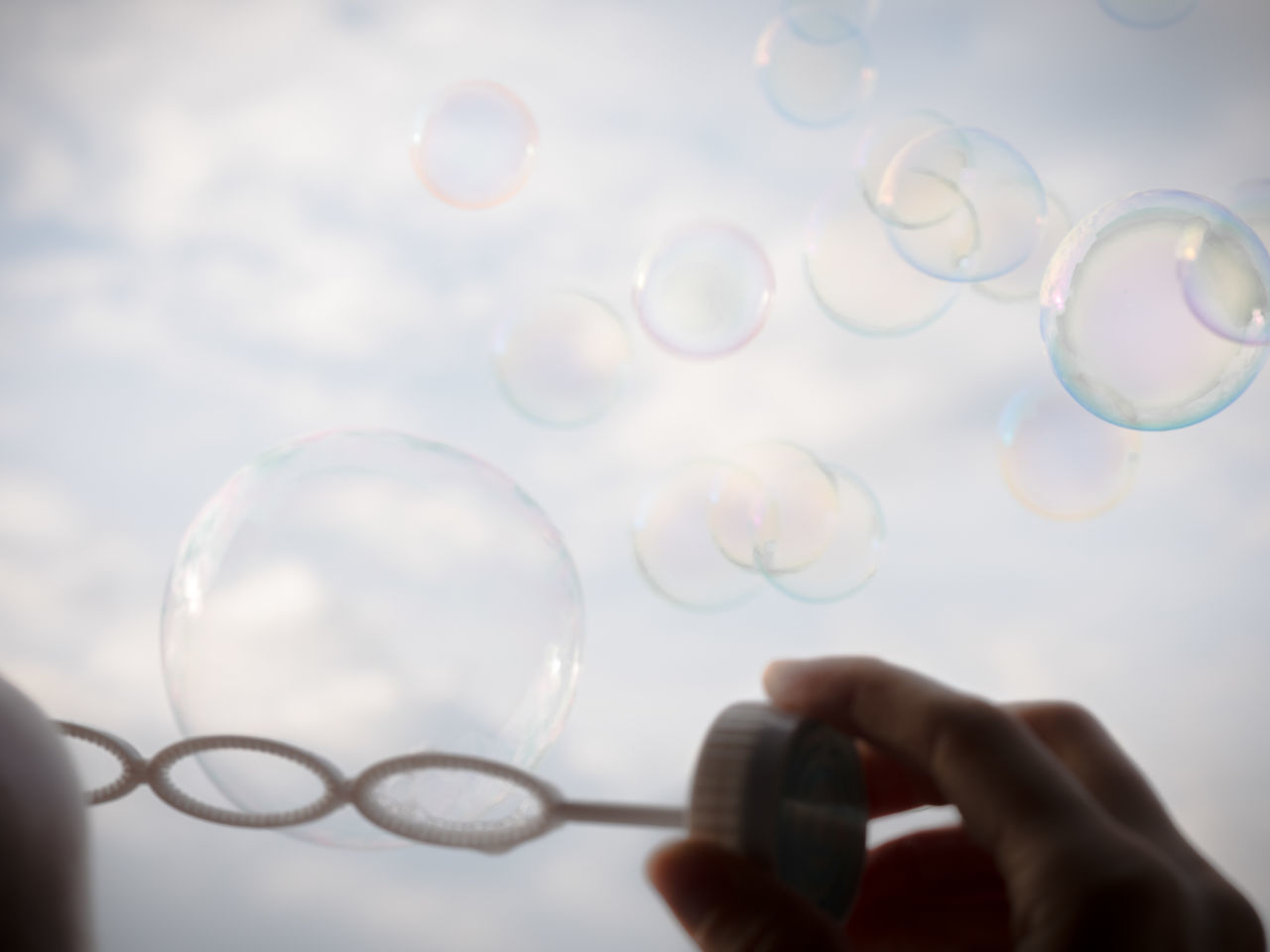 CLOSE-UP OF HAND HOLDING BUBBLES