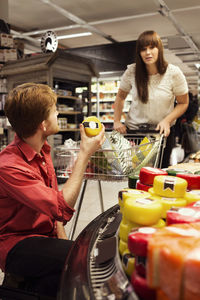 Couple shopping cheese at supermarket