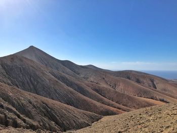 Scenic view of mountains against clear blue sky