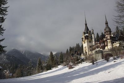 Low angle view of castle against cloudy sky during winter