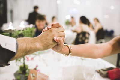 Midsection of couple holding hands