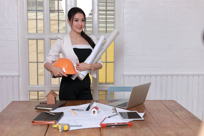 Young woman using smart phone while standing on table