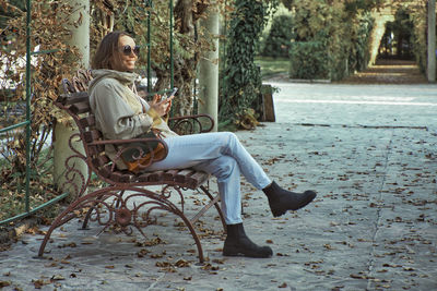 Woman sitting on chair against plants