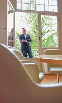 Portrait of smiling businessman standing at balcony