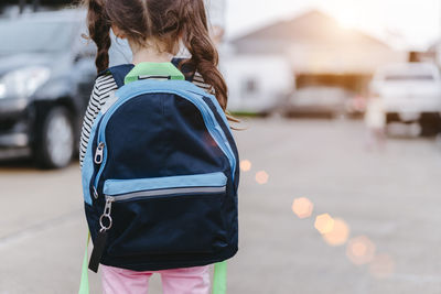 Rear view of girl with backpack on street