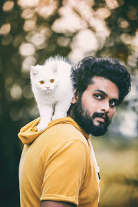 Portrait of young man with cat