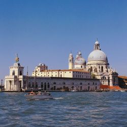View of buildings at waterfront against clear sky