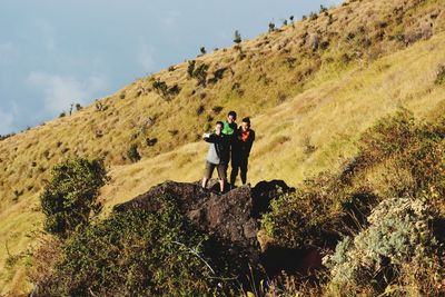 People standing on mountain against sky