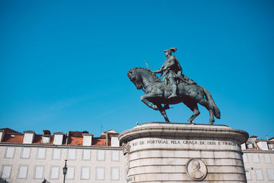 Low angle view of statue against blue sky