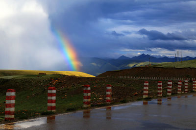 Scenic view of rainbow over mountain against sky