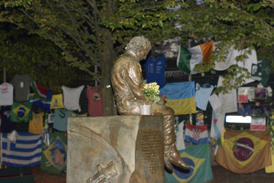 Statue against trees at cemetery