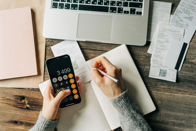 Cropped hands of man using calculator