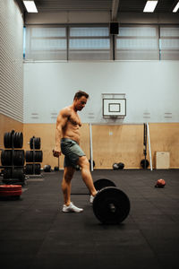 Shirtless man exercising in gym