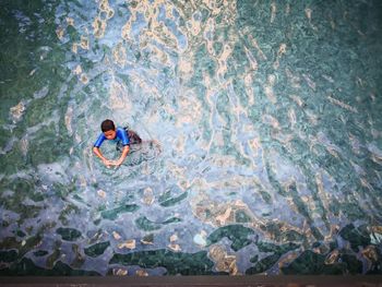 High angle view of boy swimming in sea