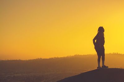 Silhouette man standing on landscape against clear sky