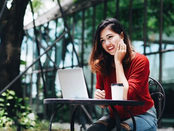 Portrait of smiling young woman using mobile phone