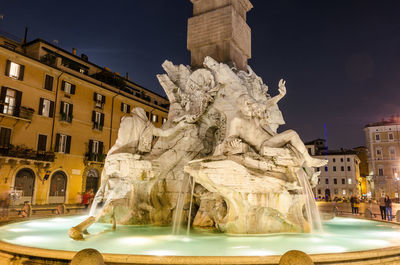 Statue fountain in city against sky