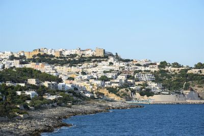 View of town by sea against clear sky