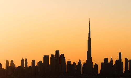 Silhouette of buildings against sky during sunset