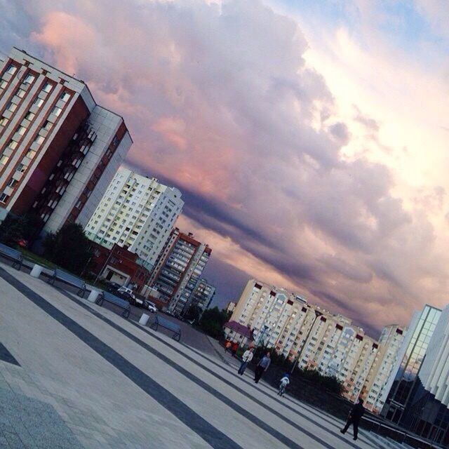 architecture, built structure, building exterior, sky, cloud - sky, cloudy, city, low angle view, modern, skyscraper, men, building, cloud, office building, tall - high, city life, lifestyles, weather, outdoors