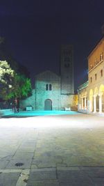 View of city street and buildings at night