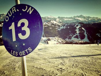 Close-up of road sign on snow covered landscape