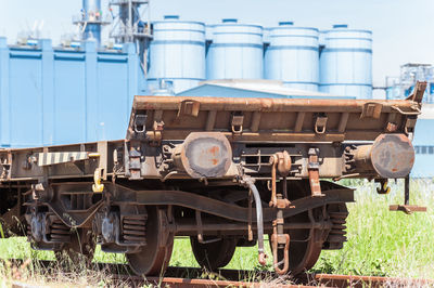 Close-up of abandoned train on railroad track against sky