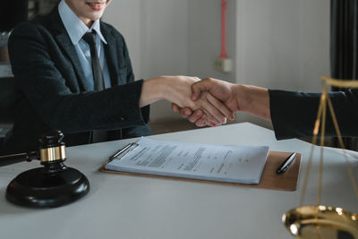 Midsection of lawyer shaking hands