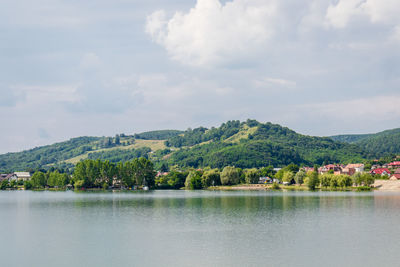 Scenic view of lake by trees against sky