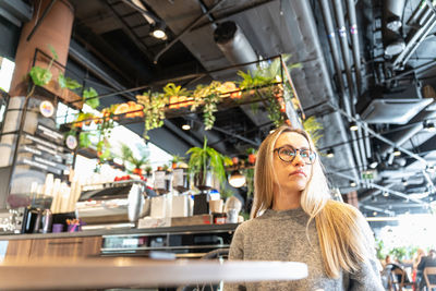 Portrait of young woman standing in store