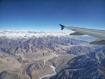 Cropped image of airplane flying over mountains