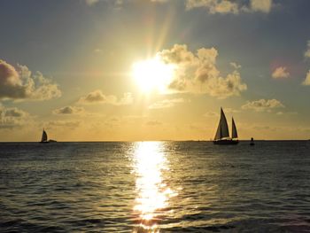 Sailboat in sea against sky during sunset